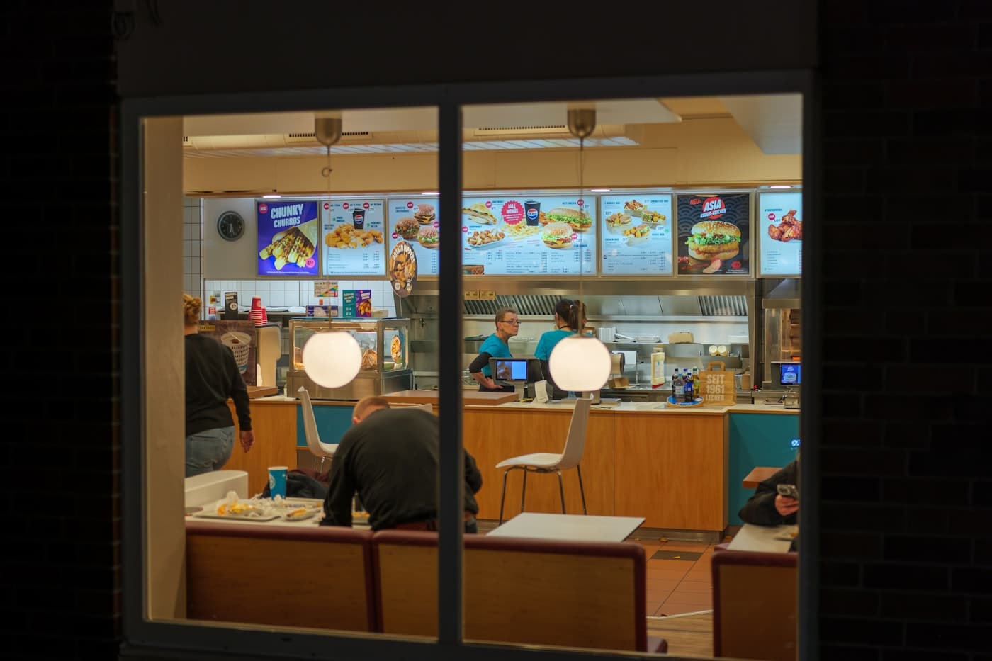 Late-night fast food counter seen through the window