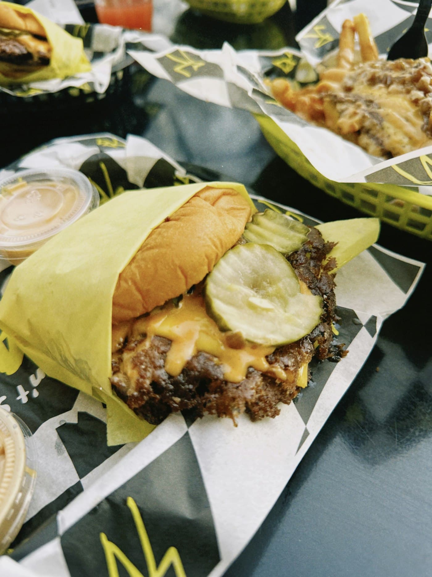 Smash burger in a branded wrapper with loaded fries